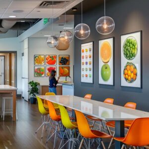 a sleek, modern office space in stamford, featuring a vibrant nutrition coach engaging with clients over colorful meal plans and lifestyle charts, illuminated by soft, warm lighting that enhances the inviting atmosphere.