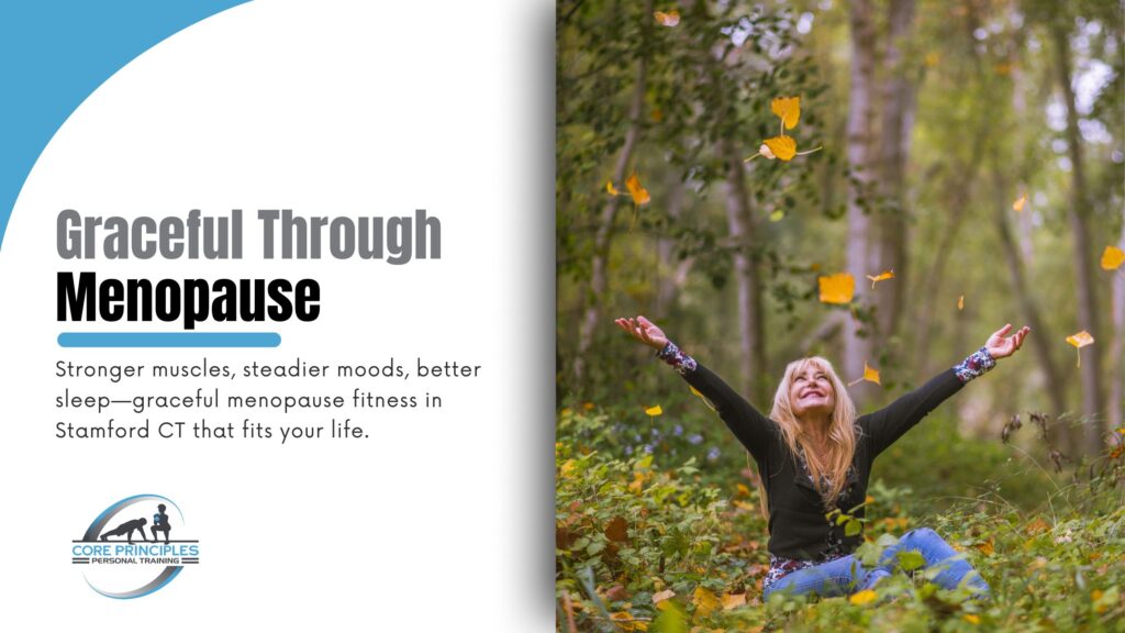 50+ smiling with arms raised among falling autumn leaves, symbolizing graceful menopause fitness in Stamford CT.