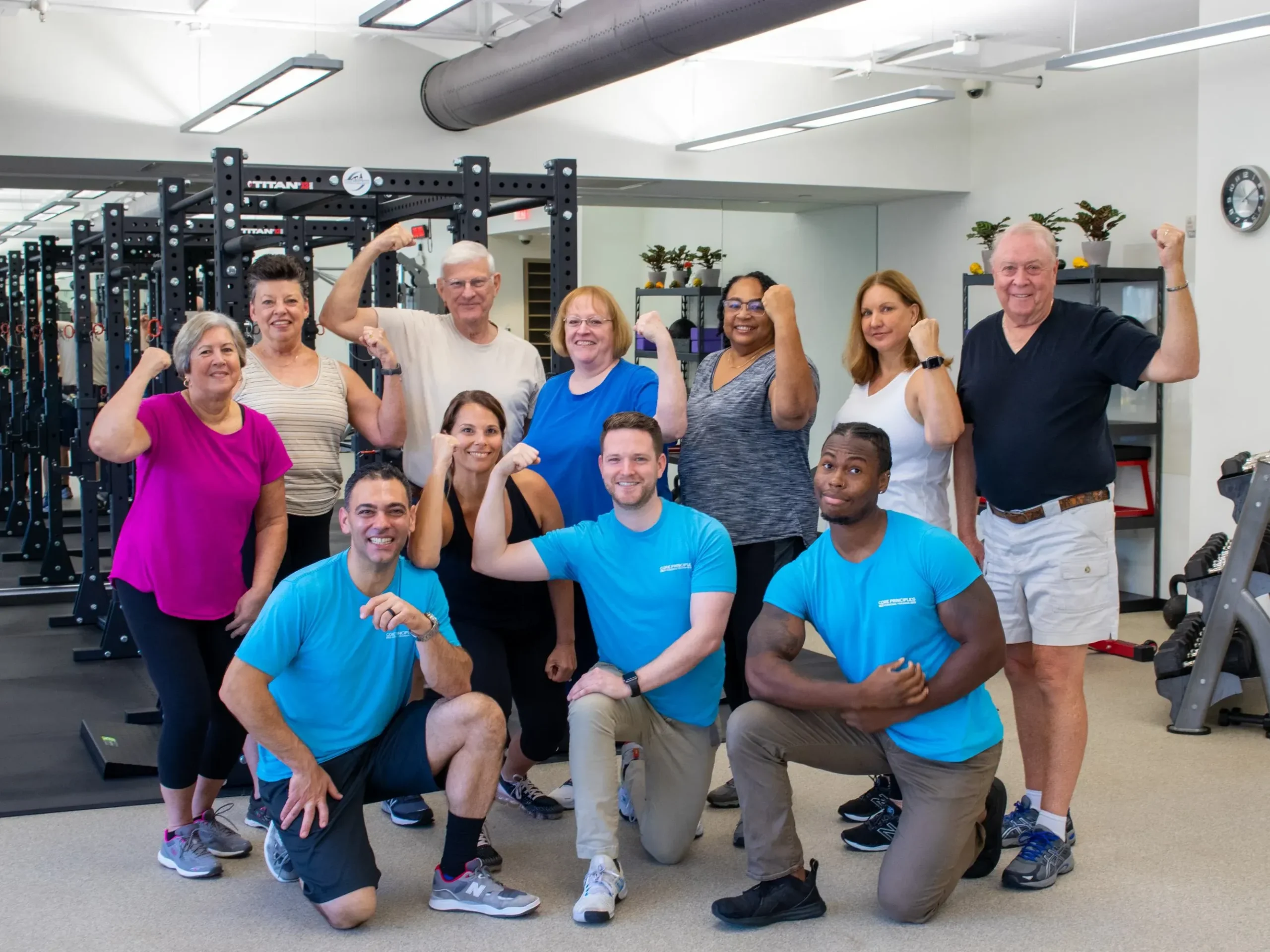 Group of diverse individuals posing in a gym, showcasing strength and fitness